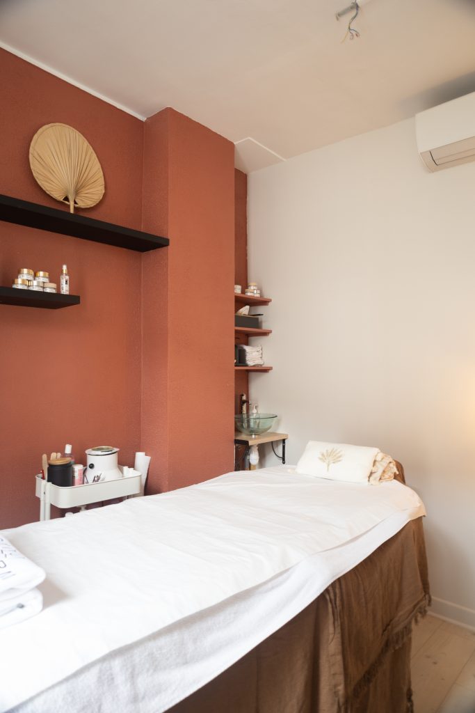 Vue complète d’une cabine de soin décorée dans un style bohème chic avec matériaux naturels
